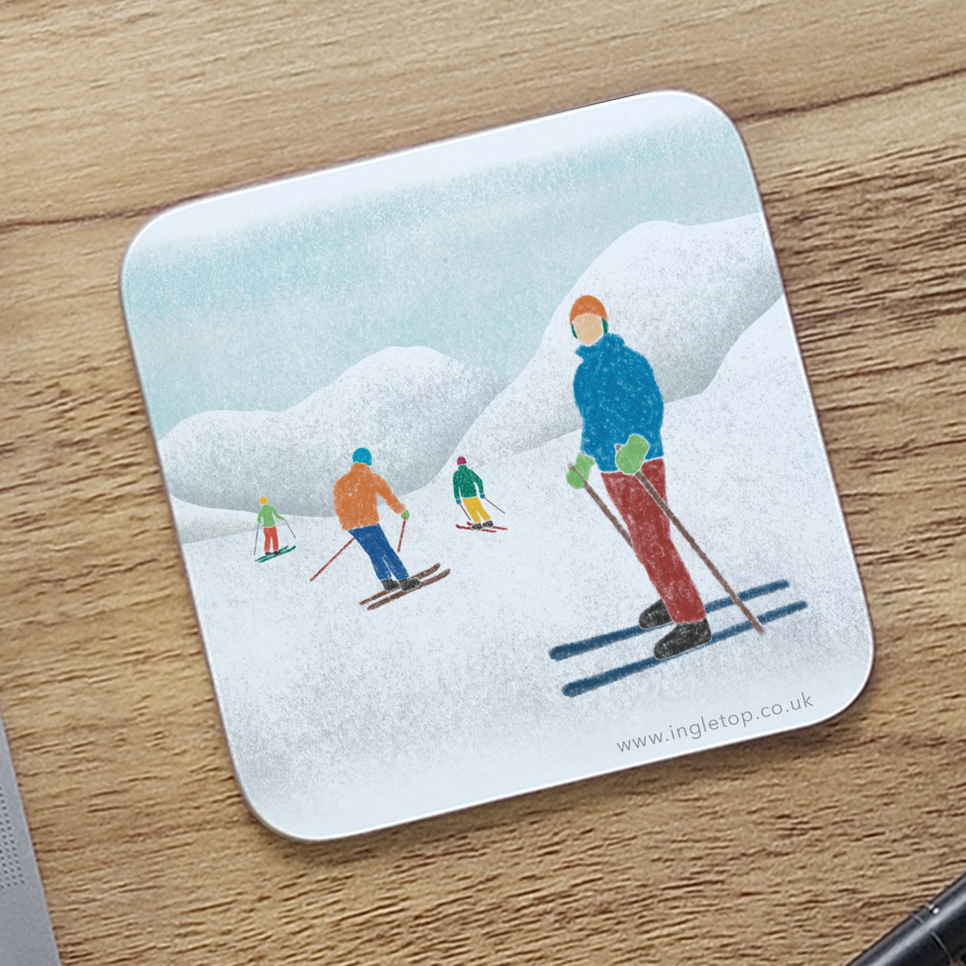 Coaster with skiers design on a wooden surface
