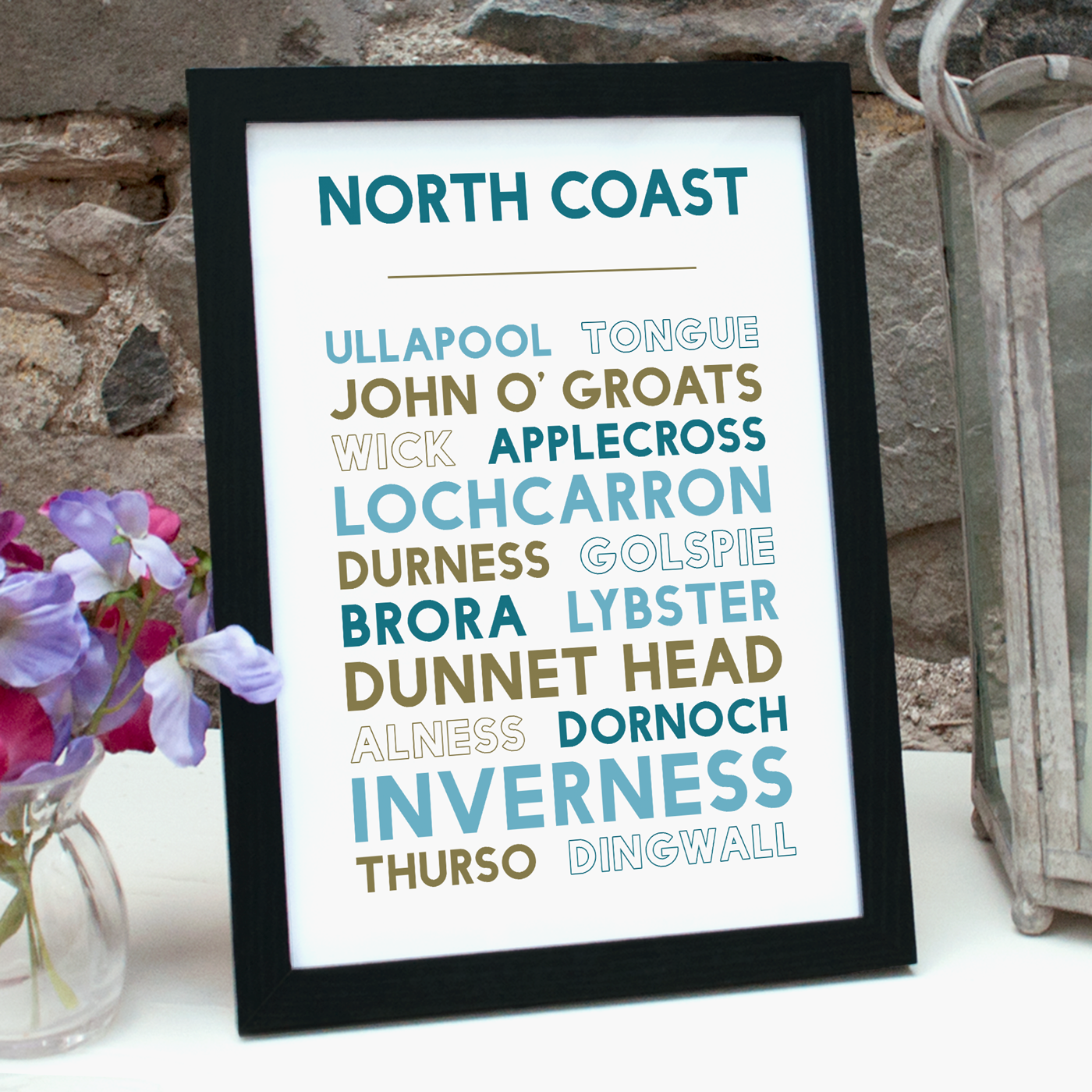 Print with names of places around the North Coast of Scotland in a black frame, standing on a table
