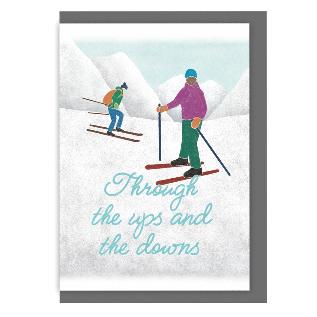 Greetings card with skiers on a snowy mountain and the text 'Through the ups and the downs', on a white background