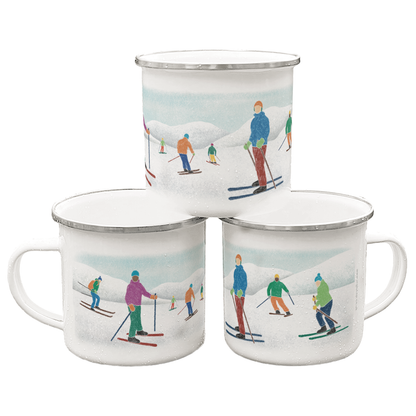 A stack of three enamel mugs printed with illustrations of skiers on a white background