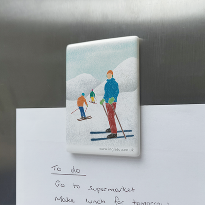 Rectangular ceramic magnet, decorated with an illustration of three skiers in a snowy mountain landscape, holding a paper "to do" list onto a metal surface